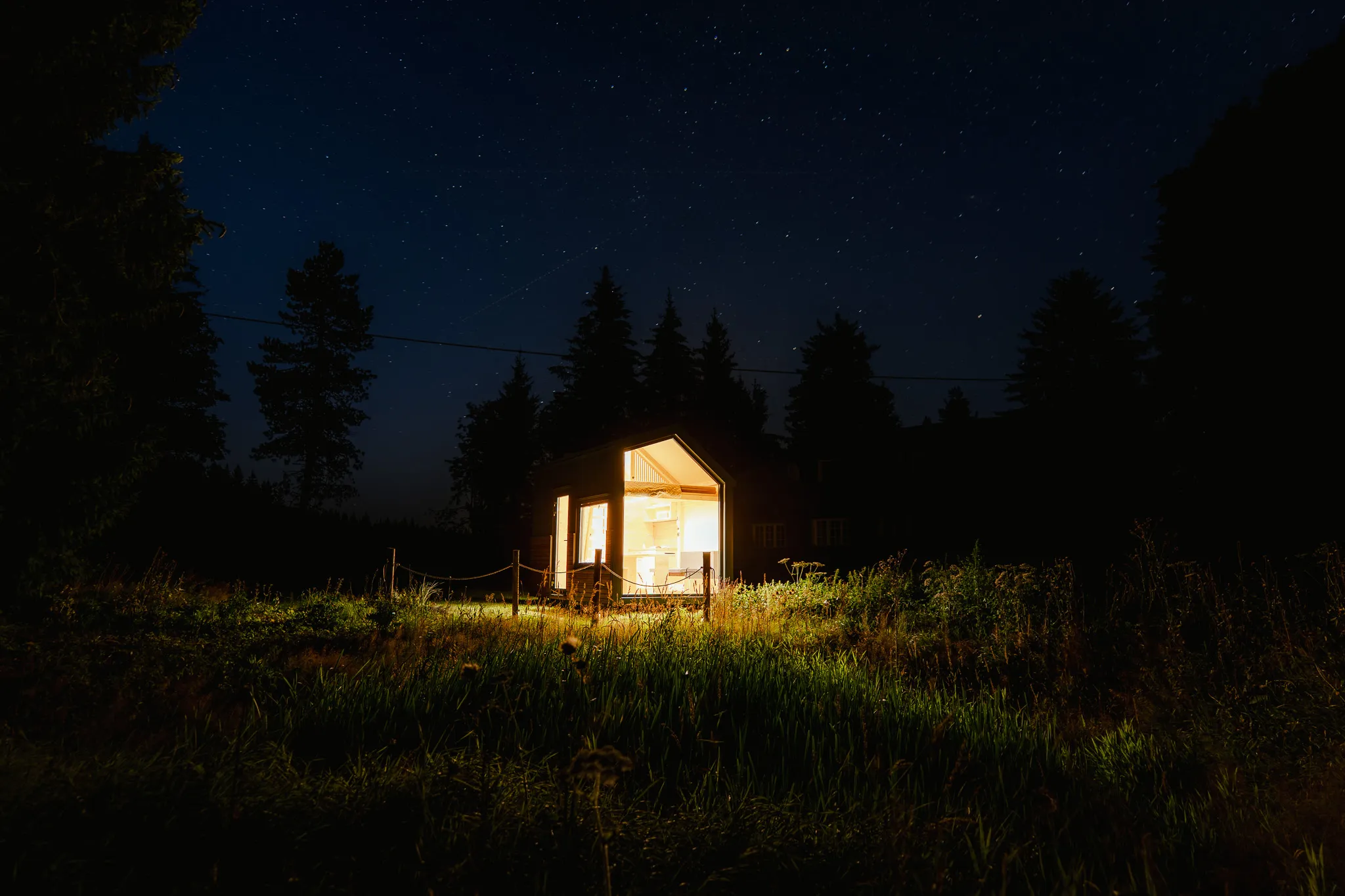 Rozsvícený domek Glamp Ili pod hvězdnou oblohou na šumavské louce